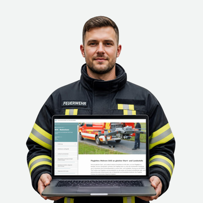 Feuerwehmann hält Laptop mit Online-Schulung: BOS-Wissen für Fernpiloten