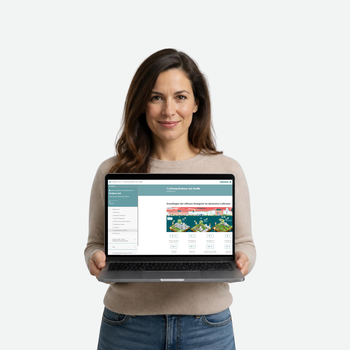Angehende Drohnenpilotin hält Laptop in die Kamera mit Online-Kurs: Drohnen 1x1